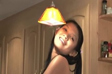 Азиатская сексуальная девушка раздевается на кухне
